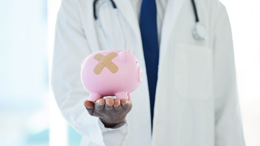 Physician holding a piggy bank