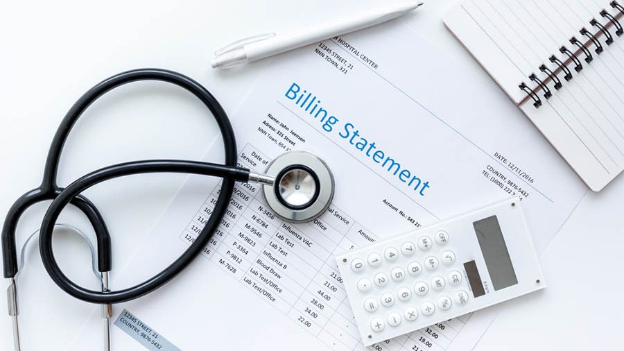 Hospital bill, calculator and a stethoscope